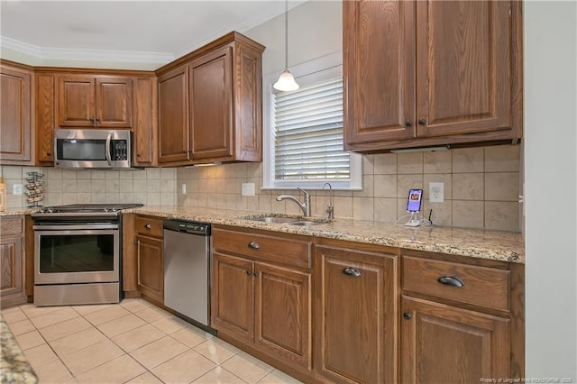 kitchen featuring backsplash, sink, decorative light fixtures, light stone counters, and stainless steel appliances