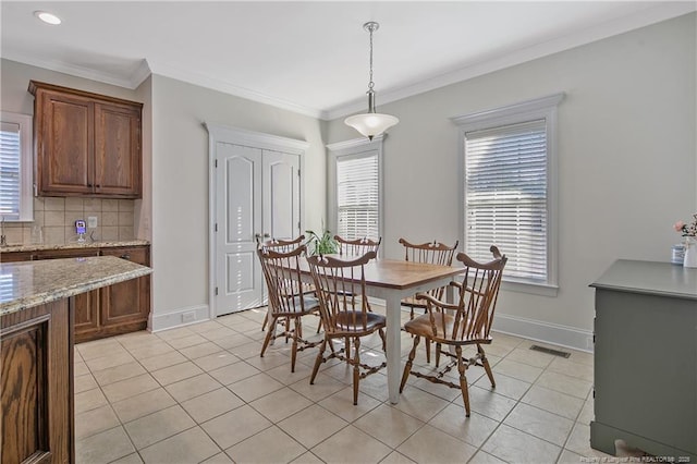 dining space featuring light tile patterned floors, a wealth of natural light, and ornamental molding