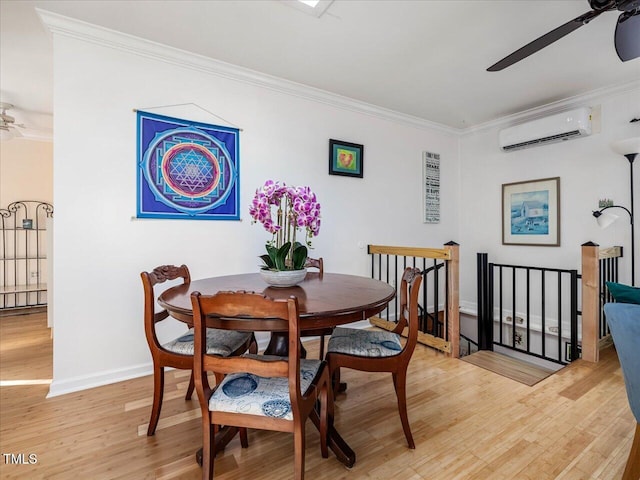 dining room featuring an AC wall unit, crown molding, ceiling fan, and light wood-type flooring