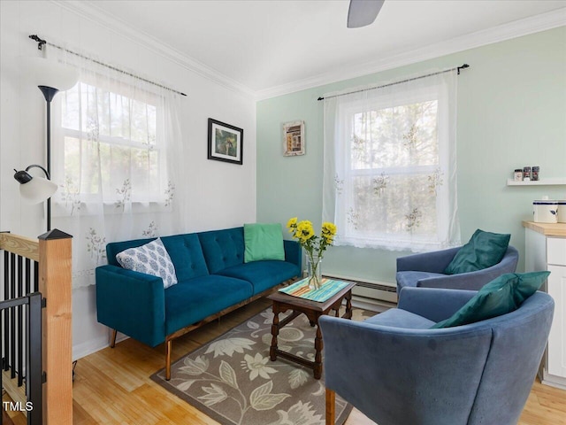 living room featuring a baseboard heating unit, a wealth of natural light, crown molding, and light hardwood / wood-style flooring