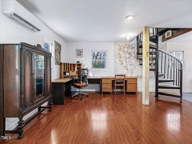 office featuring an AC wall unit, plenty of natural light, and hardwood / wood-style flooring