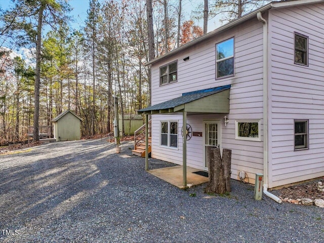 view of front of home with a patio area and a storage shed