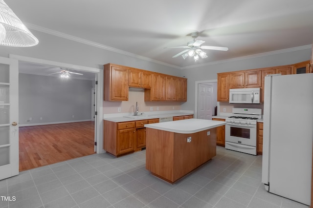 kitchen featuring ceiling fan, a center island, sink, white appliances, and ornamental molding