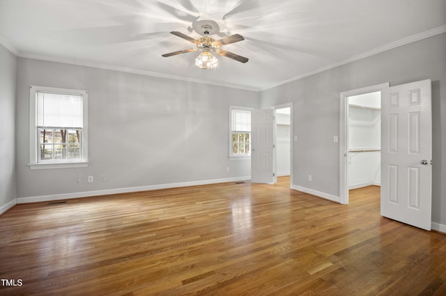 unfurnished room with ceiling fan, plenty of natural light, ornamental molding, and hardwood / wood-style flooring