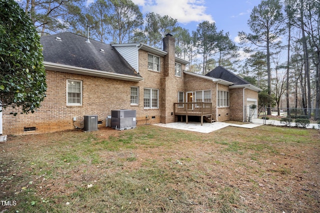 rear view of property with a lawn, central air condition unit, and a wooden deck