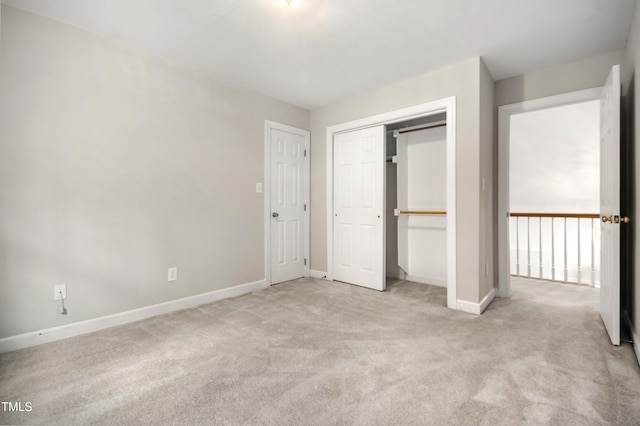 unfurnished bedroom with light colored carpet and a closet