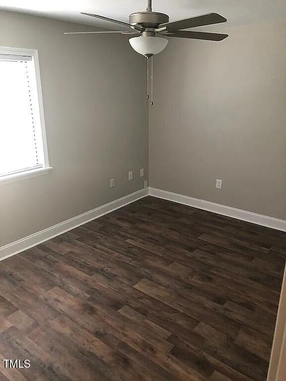 empty room featuring dark hardwood / wood-style flooring and ceiling fan