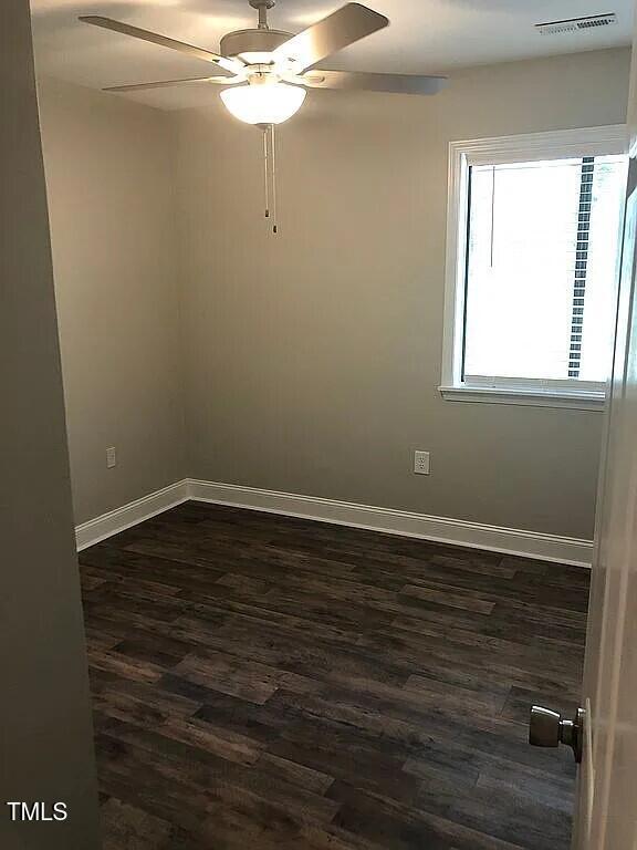 empty room featuring dark hardwood / wood-style floors and ceiling fan