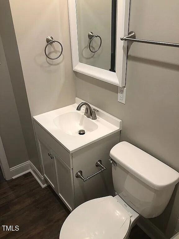 bathroom with hardwood / wood-style floors, vanity, and toilet