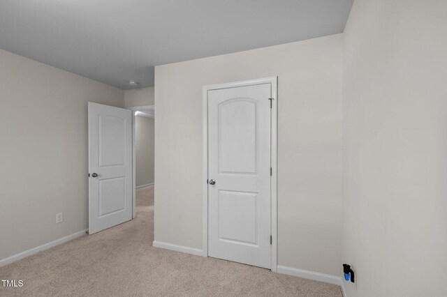 unfurnished bedroom featuring light carpet