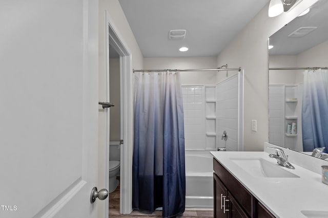 full bathroom with toilet, vanity, wood-type flooring, and shower / bath combo