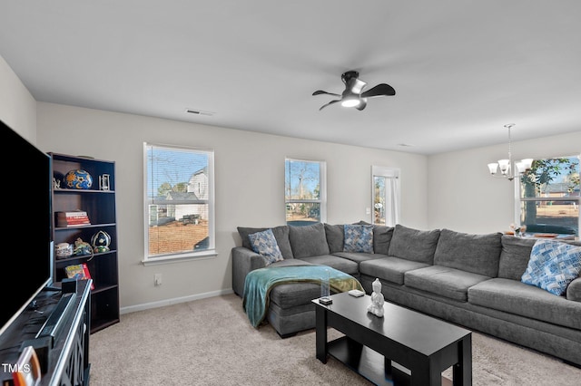 living room with ceiling fan with notable chandelier and light carpet