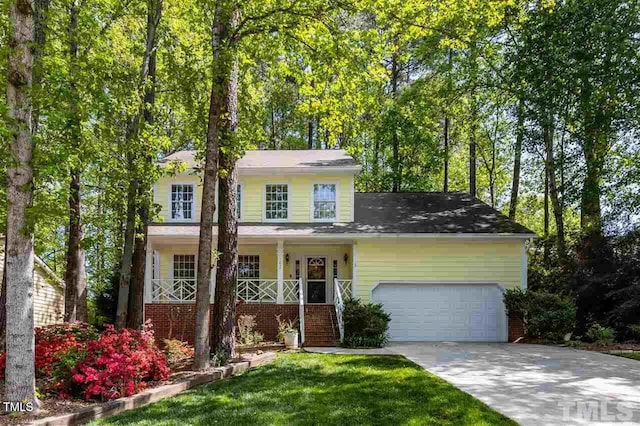 view of front of house featuring a front lawn, covered porch, and a garage