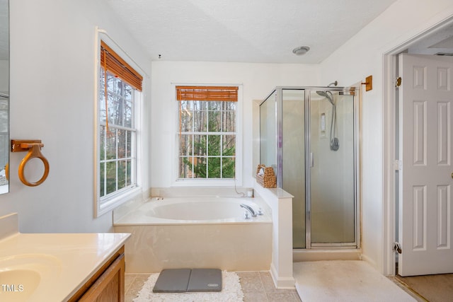 bathroom featuring tile patterned floors, vanity, independent shower and bath, and a textured ceiling