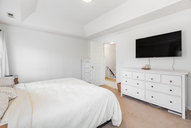 carpeted bedroom featuring a raised ceiling