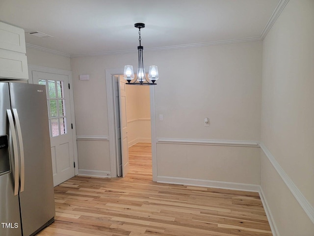interior space with light hardwood / wood-style flooring, an inviting chandelier, and crown molding
