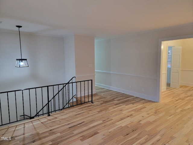 empty room featuring crown molding and light hardwood / wood-style flooring