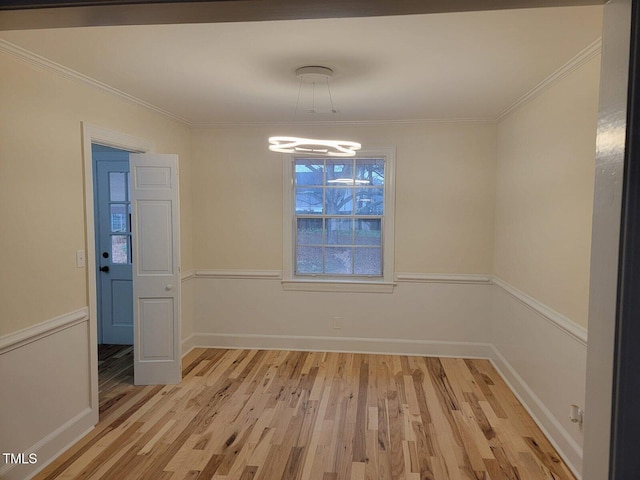 unfurnished dining area featuring light wood-type flooring, ornamental molding, and an inviting chandelier
