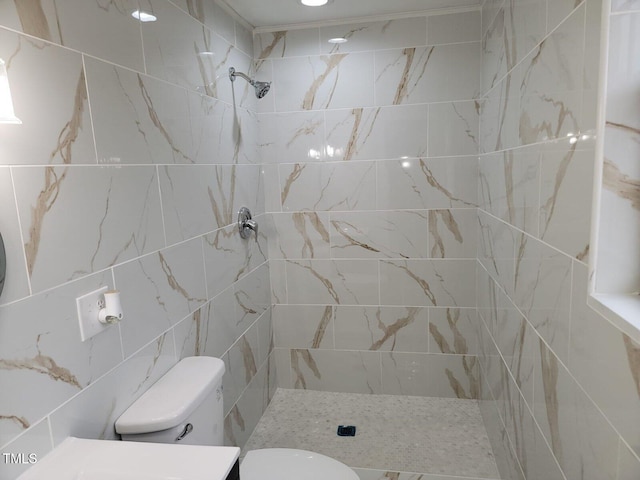 bathroom with tiled shower and toilet