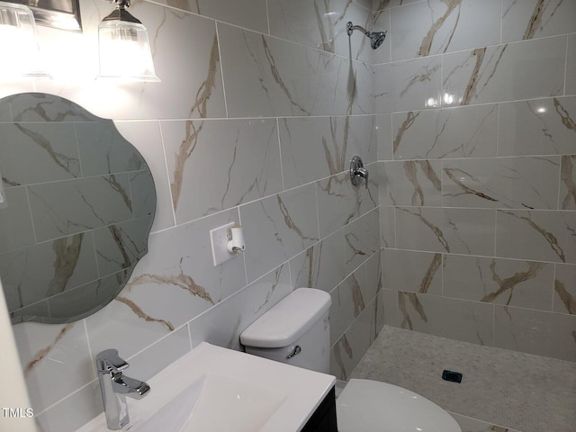 bathroom with toilet, a tile shower, and sink