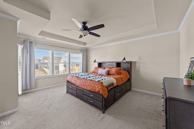 bedroom with crown molding, light carpet, ceiling fan, and a tray ceiling