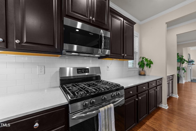 kitchen with crown molding, appliances with stainless steel finishes, dark hardwood / wood-style floors, tasteful backsplash, and dark brown cabinetry