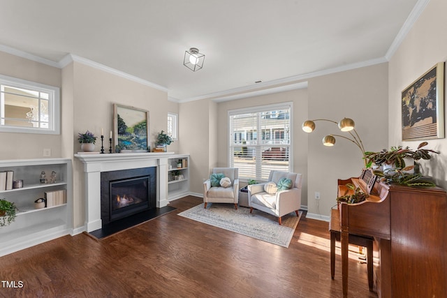 sitting room with ornamental molding and dark wood-type flooring