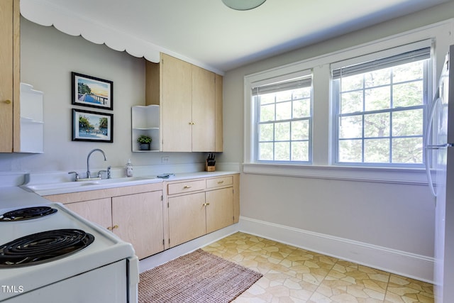 kitchen with white appliances, sink, and light brown cabinetry