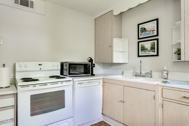 kitchen with white appliances, sink, and light brown cabinetry