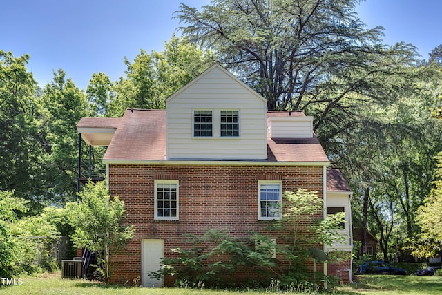 view of side of home featuring a lawn and central air condition unit