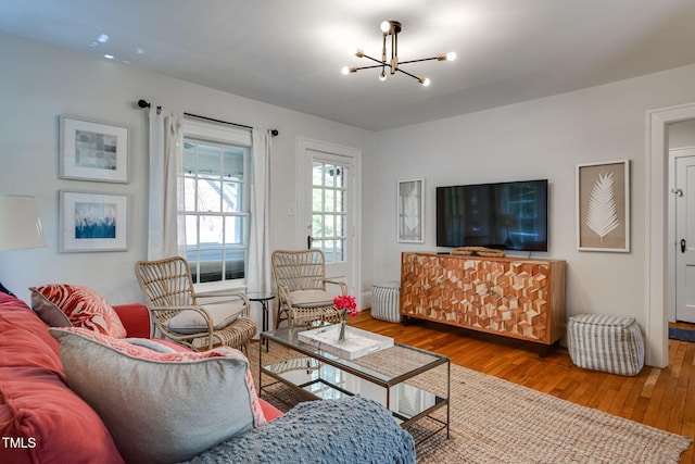 living room featuring wood-type flooring and an inviting chandelier