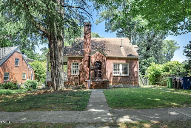 english style home featuring a front yard