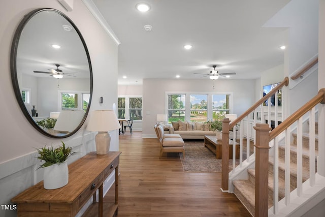 living room featuring recessed lighting, wood finished floors, baseboards, and stairs