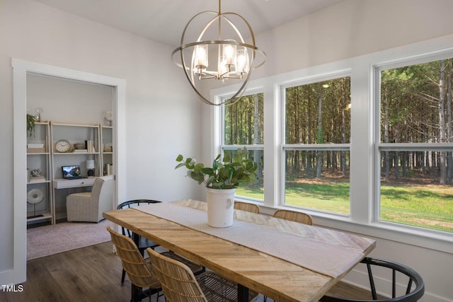 dining area with dark hardwood / wood-style flooring and an inviting chandelier