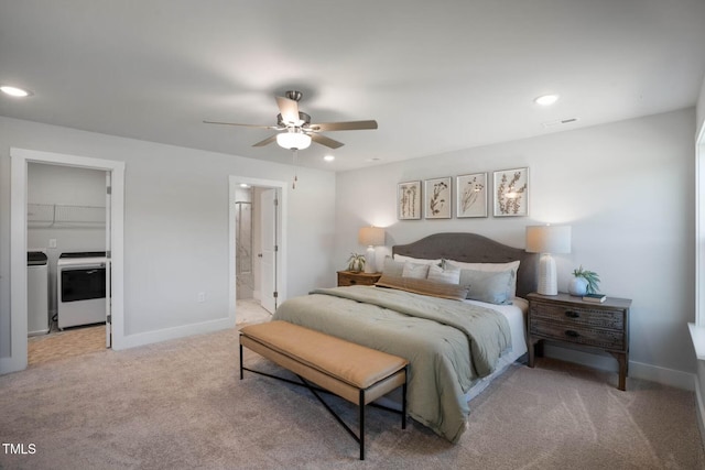 bedroom with carpet flooring, ensuite bath, ceiling fan, washing machine and dryer, and a walk in closet