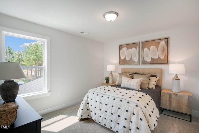 bedroom with baseboards, visible vents, and light colored carpet