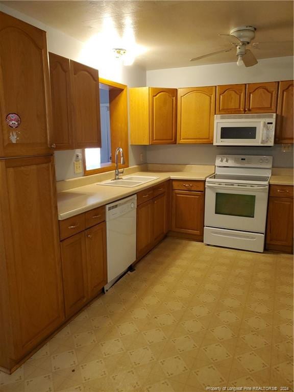 kitchen featuring white appliances, ceiling fan, and sink