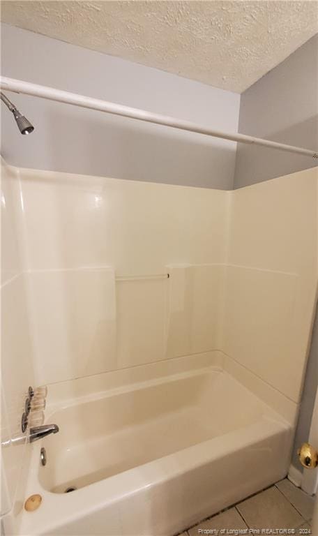 bathroom featuring a textured ceiling, shower / bath combination, and tile patterned floors