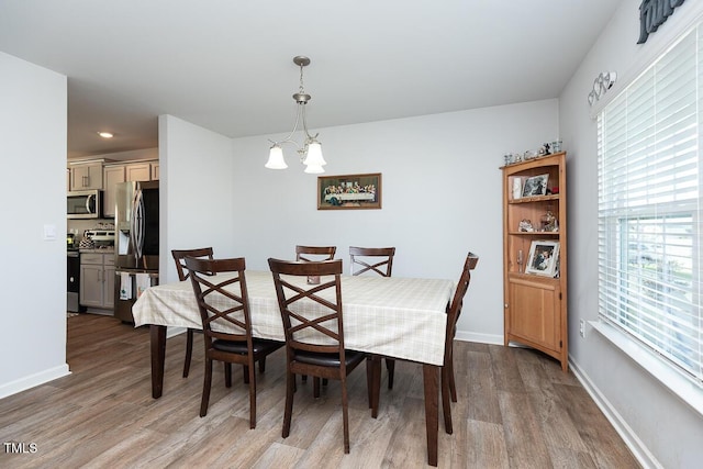 dining room with light hardwood / wood-style floors and a chandelier