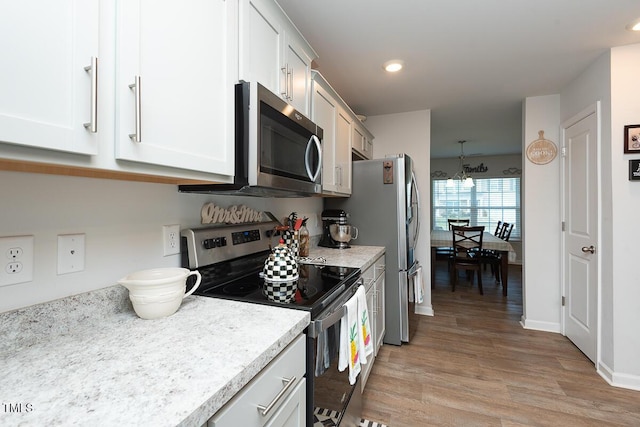 kitchen featuring a notable chandelier, white cabinetry, appliances with stainless steel finishes, and light hardwood / wood-style flooring