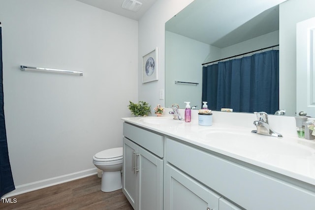 bathroom featuring vanity, hardwood / wood-style flooring, and toilet