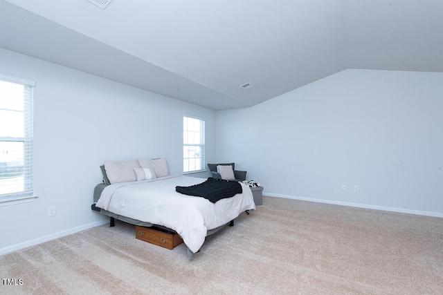 bedroom featuring light colored carpet and lofted ceiling