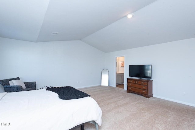 bedroom featuring light carpet, connected bathroom, and lofted ceiling