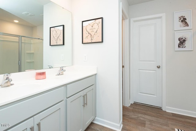 bathroom featuring hardwood / wood-style floors, vanity, and a shower with door