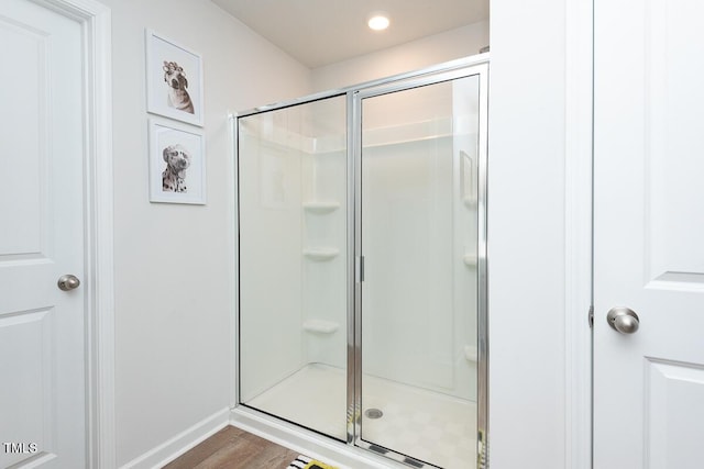 bathroom featuring an enclosed shower and hardwood / wood-style flooring