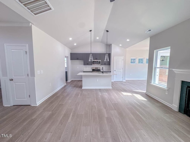 kitchen featuring sink, gray cabinets, appliances with stainless steel finishes, decorative light fixtures, and light hardwood / wood-style floors