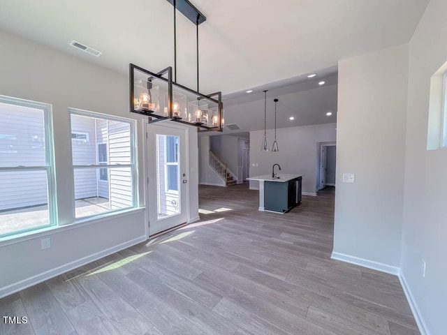 unfurnished dining area with dark hardwood / wood-style floors, a notable chandelier, and sink