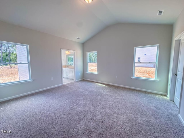 carpeted empty room featuring lofted ceiling