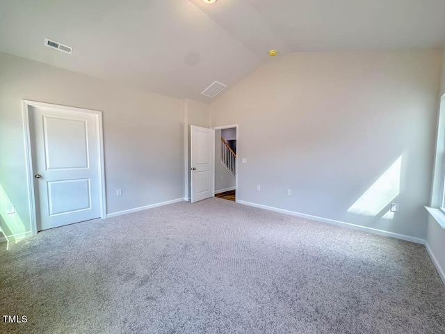 carpeted empty room featuring lofted ceiling