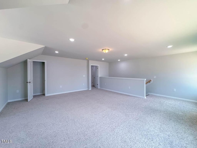 interior space with light carpet and vaulted ceiling